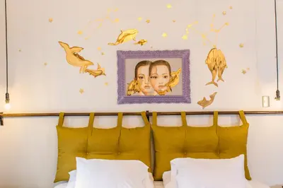 a bedroom with a bed with a picture on the wall at X.O Art House in Cusco