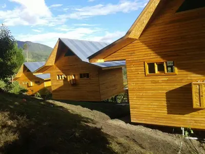 a group of wooden homes with solar panels on them at San Alberto Ecolodge in Oxapampa