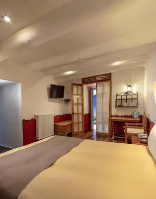 a bedroom with a large bed and a desk at Tambo del Arriero Hotel Boutique in Cusco
