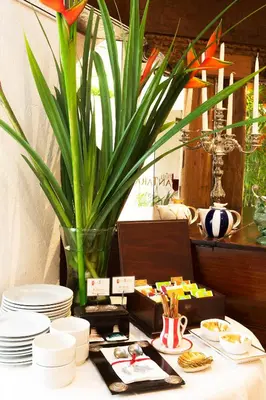 a table with plates and a vase with a plant at Antara Hotel & Suites - Miraflores in Lima