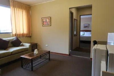 a living room with a couch and a table and a bed at Suites Larco 656 Miraflores Lima in Lima