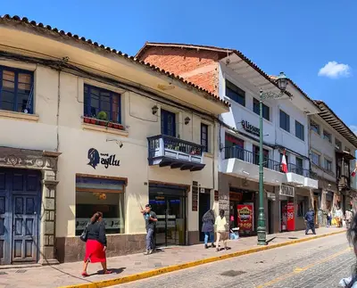 a woman walking down a street in front of a building at Apartamento en el centro Cusco Inlove in Cusco