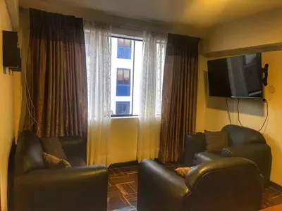 a living room with two chairs and a television at Excelente ubicación en el Centro Cusco Inlove in Cusco
