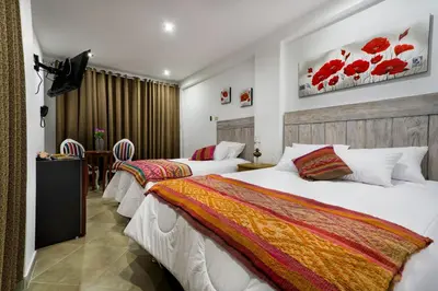 a hotel room with two beds and a table at El Encanto in Lunahuaná