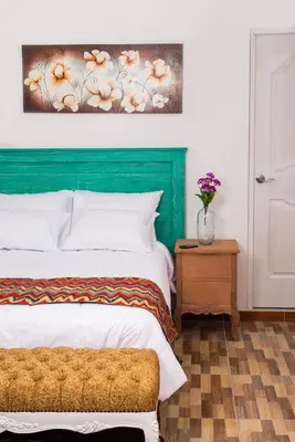 a bedroom with a bed and a painting on the wall at El Encanto in Lunahuaná