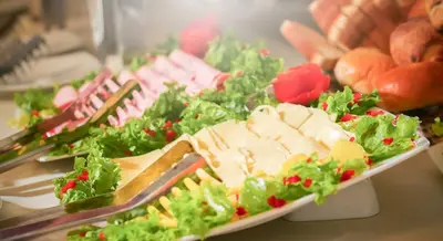 a plate of meats and vegetables on a table at Golden Sunrise Machupicchu in Machu Picchu