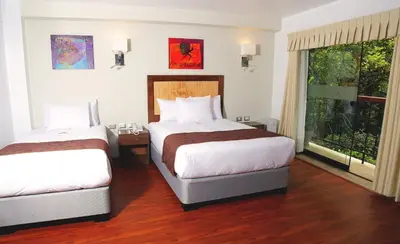 a hotel room with two beds and a window at Golden Sunrise Machupicchu in Machu Picchu