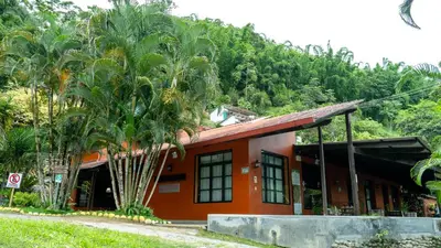 an orange building with a palm tree in front of it at Fundo San Jose Parque Ecológico & Lodge Hotel Asociado Casa Andina in La Merced