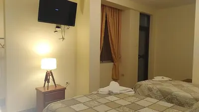 a hotel room with two beds and a television at Hotel Elizabeth Hoss in Sayán
