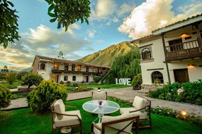 a patio with a table and chairs in front of a building at Sonesta Posadas del Inca - Valle Sagrado Yucay Urubamba in Urubamba