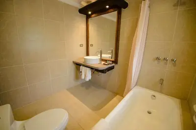 a bathroom with a toilet and a sink and a tub at Sonesta Posadas del Inca - Valle Sagrado Yucay Urubamba in Urubamba