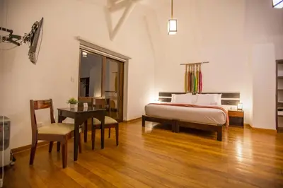a bedroom with a bed and a table and a desk at Tierra Viva Valle Sagrado Hotel in Urubamba