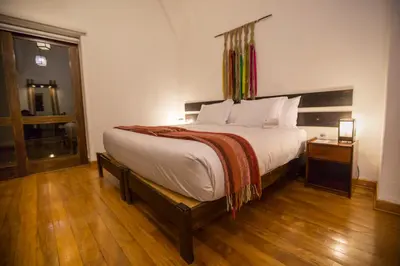 a bedroom with a large bed and a wooden floor at Tierra Viva Valle Sagrado Hotel in Urubamba