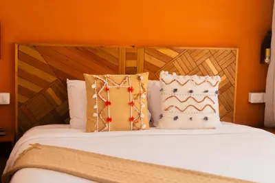 a bed with a wooden headboard and two pillows at qema Lima in Lima
