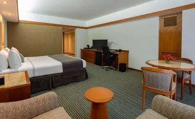 a hotel room with a bed and a desk at Sonesta Hotel El Olivar in Lima