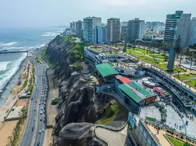 a city with a train on a mountain next to the ocean at Sonesta Hotel El Olivar in Lima