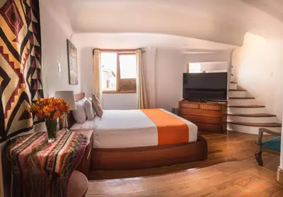 a hotel room with a bed and a television at Waman Qorikancha in Cusco