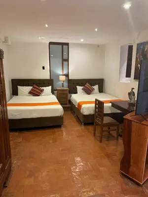 a hotel room with two beds and a television at Waman Qorikancha in Cusco