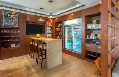 a kitchen with a bar with stools and a television at Sonesta Hotel Cusco in Cusco