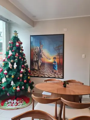 a christmas tree in a room with tables and a painting at Terraza Apart Hotel in Pichanaki