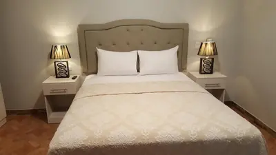 a bedroom with a bed with two lamps on tables at Terraza Apart Hotel in Pichanaki
