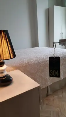 a bed with a clock on it next to a table at Terraza Apart Hotel in Pichanaki