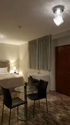 a hotel room with a bed and a table and chairs at Terraza Apart Hotel in Pichanaki