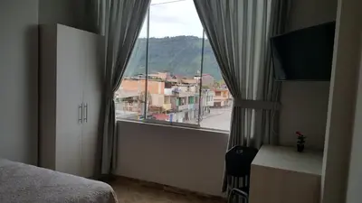 a bedroom with a window with a view of a city at Terraza Apart Hotel in Pichanaki