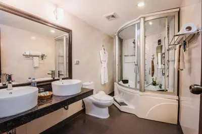 a bathroom with two sinks and a toilet and a shower at Hotel Nobility in Lima