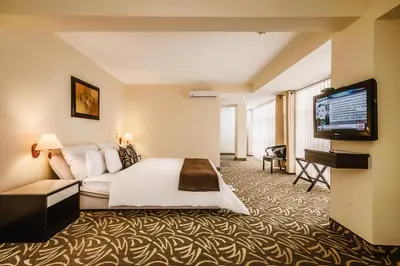 a hotel room with a bed and a flat screen tv at Hotel Nobility in Lima