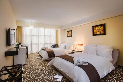 a hotel room with two beds and a television at Hotel Nobility in Lima