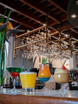 a group of four cocktails sitting on a bar at Hotel Britania San Borja in Lima