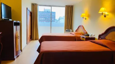 a hotel room with two beds and a large window at Hotel Continental Lima in Lima
