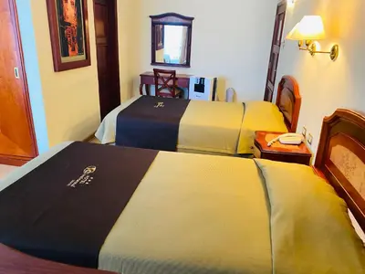 two beds in a hotel room with yellow and blue at Hotel Continental Lima in Lima