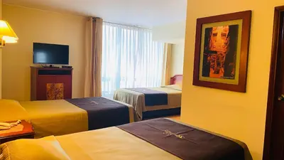 a hotel room with two beds and a television at Hotel Continental Lima in Lima