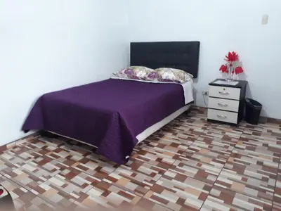 a bedroom with a purple bed and a night stand at B&B La Casa del Turista in Lima