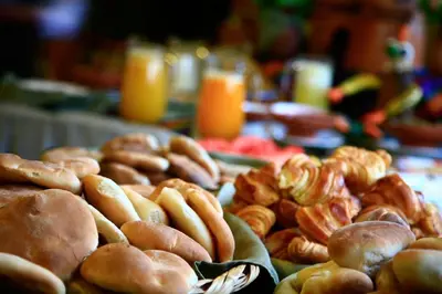 a table topped with lots of different types of pastries at Hotel San Agustin Urubamba in Urubamba