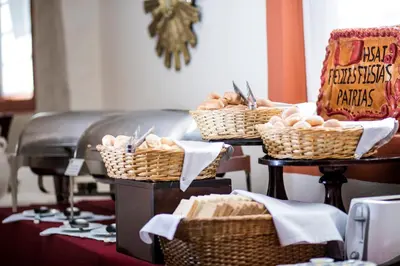 a buffet with baskets of bread and vegetables on a table at San Agustin Internacional in Cusco