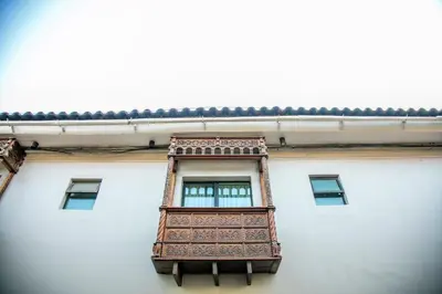 a window on the side of a white building at San Agustin Internacional in Cusco