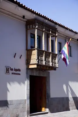 a building with a balcony and a flag at San Agustin Internacional in Cusco