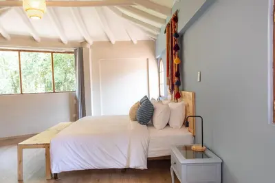 a bedroom with a large bed with white sheets and pillows at Tariq Sacred Valley in Urubamba