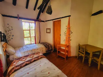 a bedroom with two beds and a window at Casa de campo Yoga Retreat in Urubamba