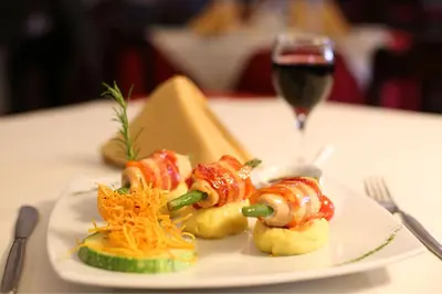 a plate of food on a table with a glass of wine at Munay Wasi Inn in Cusco