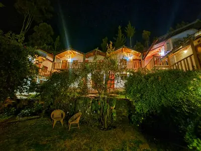 a building with two chairs in the yard at night at La Casa de Campo in Cusco