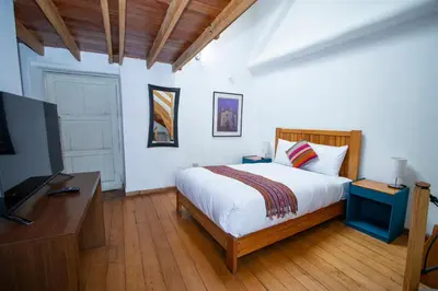 a bedroom with a bed and a flat screen tv at Inkarri Cusco in Cusco
