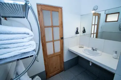 a bathroom with a sink and a mirror and towels at Inkarri Cusco in Cusco