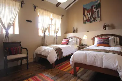 a bedroom with two beds and a chair and windows at 