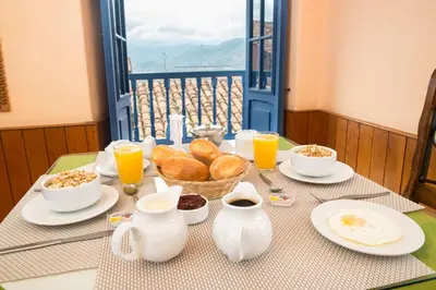 a table with a breakfast of bread and orange juice at Amaru Inca in Cusco