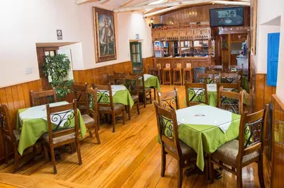 a restaurant with tables and chairs with green table cloth at Amaru Inca in Cusco