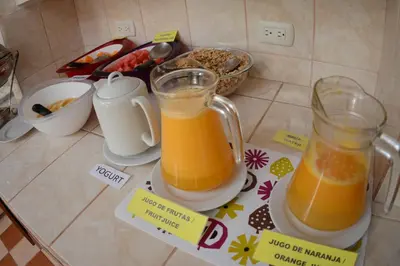 two glass jars of orange juice sitting on a counter at Hosteria de Anita in Cusco